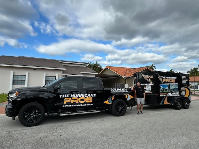 Ariel Bejerano, owner of The Hurricane Pros, standing next to the company truck and trailer