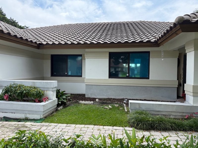 Dark-framed impact windows on a single-story tile-roof home in Miramar