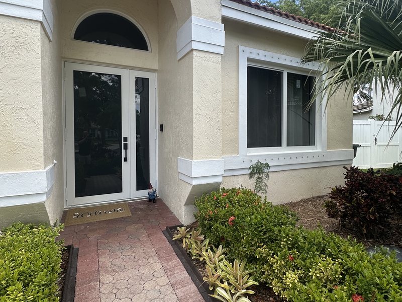 White impact double entry doors with an arched transom on a Pembroke Pines home